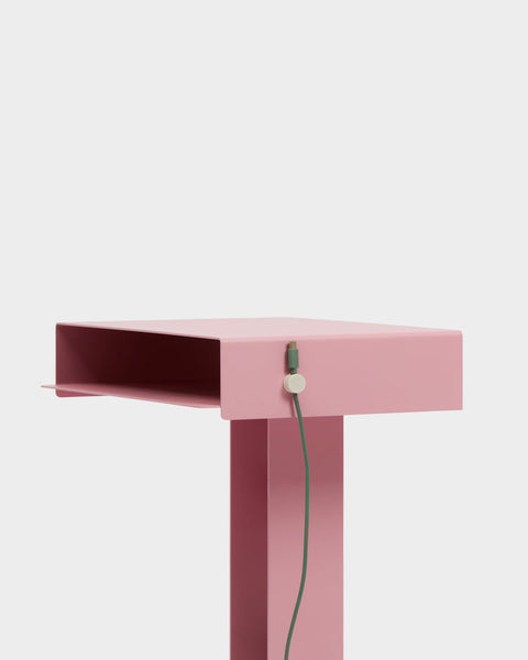 Pedestal Cable Clips in Pearl, magnetic silicone cable clip, holding a cable against the edge of a pink desk