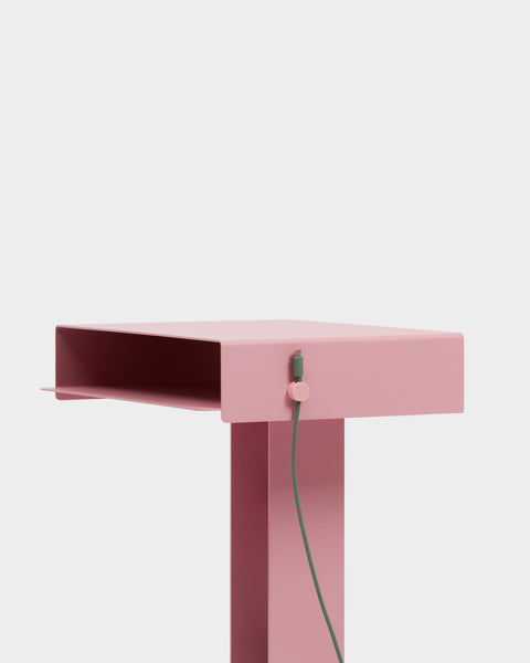 Pedestal Cable Clips in Bubble Gum, magnetic silicone cable clip, holding a cable against the edge of a pink desk