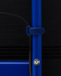 Pedestal Cable Tie in Ultra Marine, soft silicone cable tie, holding a cable against the leg of an Ultra Marine TV stand