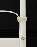 Pedestal Cable Tie in Pearl, soft silicone cable tie, holding a cable against the leg of a Pearl TV stand