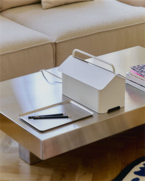 Pedestal Cable Villa in Pearl, steel cable box on wheels, standing on a desk beside a notebook and a pen