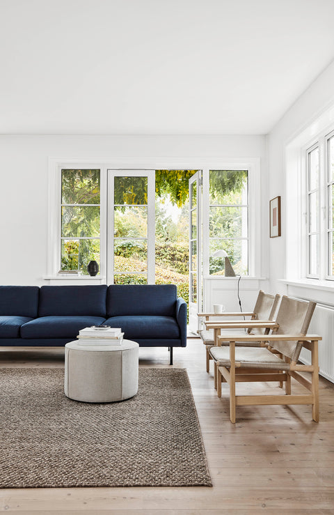 Navy Calmo 3 Seater with round ottoman and Mogensen Canvas Chairs in a bright Scandinavian living room