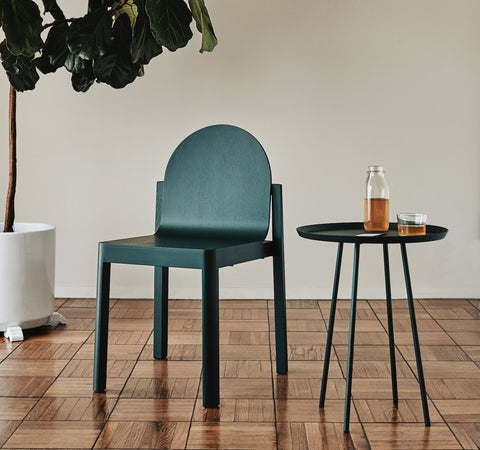Green Cleo Chair by Edits Furniture beside matching side table and glassware