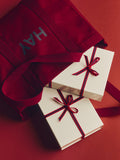 HAY Shopper Bag, Burgundy, cotton tote bag, close up of the burgundy shopper with two cream gift boxes tied in red ribbon