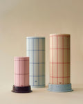 HAY Column Candle, Large, Red Grid Check, stearin pillar candles, three sizes on matching candleholders against a beige backdrop