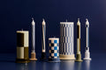 HAY Column Candleholder, Off-White, glazed ceramic candleholders, a row holding block and check candles on a dark blue surface