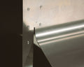 Frama Rivet Chair in Aluminum, close view of the riveted metal panel and the curved edge of the back shell catching light
