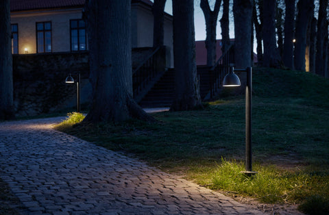 bollard lamp lighting up pathway to house by louis poulsen