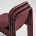 Blu Dot Decade Chairs in oxblood recycled plastic, close-up showing three chairs stacked together demonstrating the stackable design