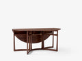 Drop Leaf HM6 table in walnut by &Tradition shown half folded with brass fittings visible