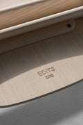 EDITS Circus Chair branding detail, Canadian furniture company mark on natural oak wood underside.