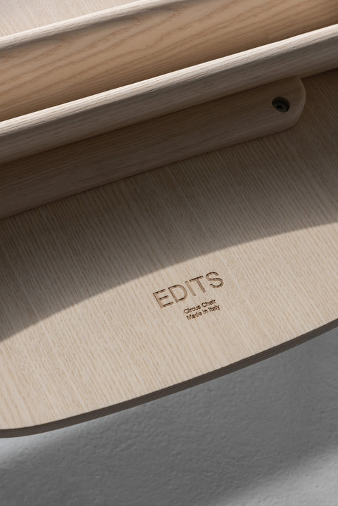 EDITS Circus Chair branding detail, Canadian furniture company mark on natural oak wood underside.