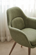 Detail of Swoon Dining Chair with oak wood base in green fabric upholstery by Fredericia.