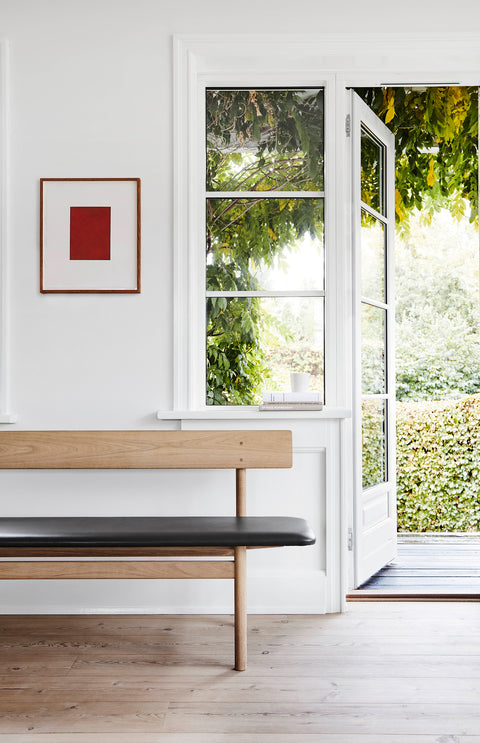 Borge Mogensen 3171 bench in oak with black leather seat by a bright window, Scandinavian entryway seating