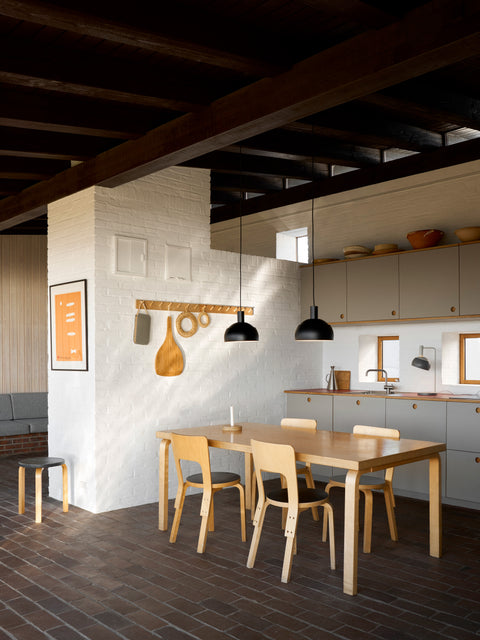 Finn Juhl Elements pendant lamp in black by Louis Poulsen over Scandinavian Artek dining table and dining chairs in modern kitchen interior Canada