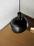 Close up of Finn Juhl Elements pendant lamp in black by Louis Poulsen above oak table modern Scandinavian pendant light Canada