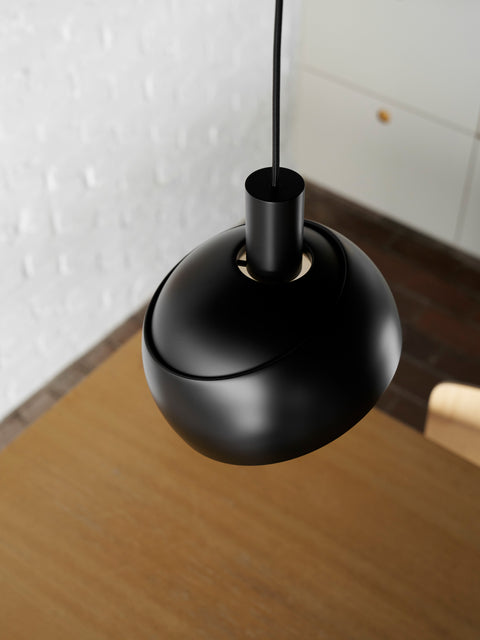 Close up of Finn Juhl Elements pendant lamp in black by Louis Poulsen above oak table modern Scandinavian pendant light Canada