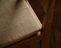Frama Bar Chair 01 Cushion in Camel, close view of the woven seat pad sitting on the seat of a dark wood bar chair