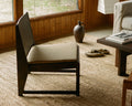Frama Easy Chair 01 Cushion in Camel, pale seat cushion on a dark low chair by a window in a wood panelled room with a woven rug
