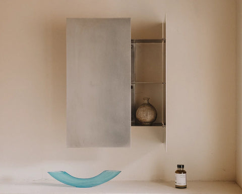Frama Sheet Cabinet in Stainless Steel, steel wall cabinet with one door open showing shelves, a blue glass dish on the ledge below