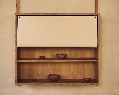 Frama Shelf Library Canvas Cabinet Section in Natural Oak, canvas front rolled up to show two oak shelves holding small turned wooden bowls