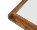 Frama Symmetry Mirror, close up of the frame corner showing the grain of the brown wood and the lipped edge that holds the glass