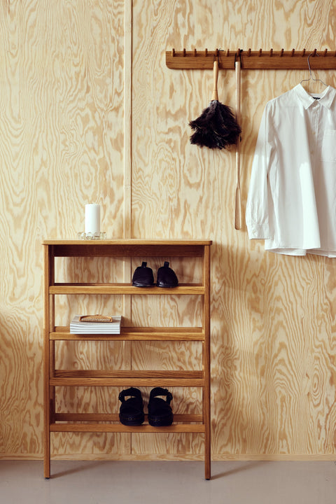 Form & Refine A Line Shoe Rack 72, solid oak shoe rack, oak shoe rack holding shoes beneath a coat rack with a white shirt on a plywood wall