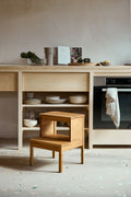 Form & Refine A Line Stepstool, solid oak step stool, oak step stool in a kitchen beside an oak cabinet with dishes and bowls