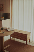 Form & Refine A Line Storage Bench 90, oak storage bench with lid, oak storage bench beside a round table in a plywood-lined kitchen