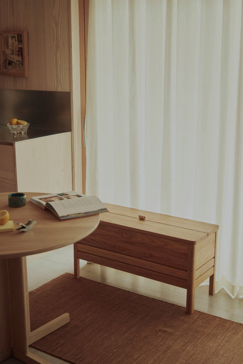 Form & Refine A Line Storage Bench 90, oak storage bench with lid, oak storage bench beside a round table in a plywood-lined kitchen