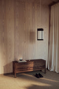 Form & Refine A Line Storage Bench 111, oak storage bench with lid, black stained oak storage bench in a wood-panelled entrance beneath a paper wall lamp