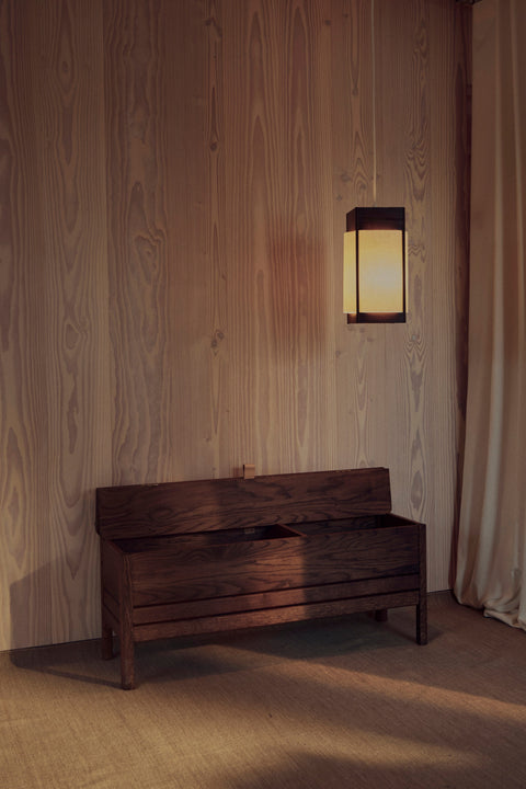 Form & Refine A Line Storage Bench 111, oak storage bench with lid, black stained oak storage bench with the lid open in a wood-panelled entrance