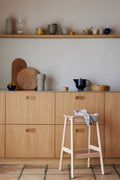 Form & Refine Angle Bar Stool 65, wooden bar stool, beech bar stool with a folded towel in an oak kitchen with open shelves