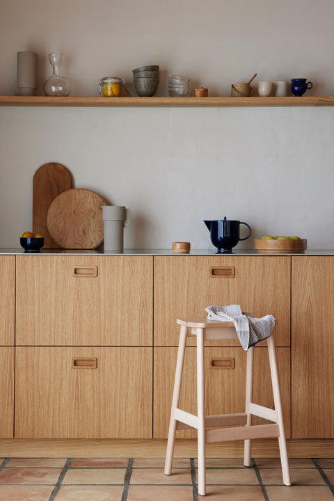 Form & Refine Angle Bar Stool 65, wooden bar stool, beech bar stool with a folded towel in an oak kitchen with open shelves