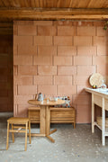 Form & Refine Angle Foldable Stool, folding oak stool, oak foldable stool at a round table in a kitchen with a terracotta tiled wall