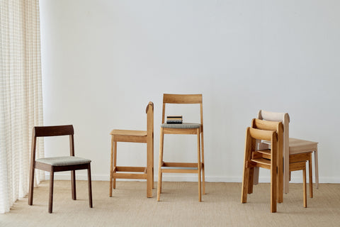 Form & Refine Blueprint Bar Chair 65, solid oak bar chair, Blueprint chairs and bar chairs in oak and black grouped on a rug in a white room