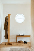 Form & Refine Foyer Coat Stand, solid oak coat stand, oak coat stand with coats in a whitewashed entrance next to a bench and a round window