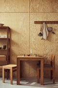 Form & Refine Leaf Shelf 0.5x5, tall oak shelving unit, tall oak shelf beside a square table with Sonder chairs against a plywood wall