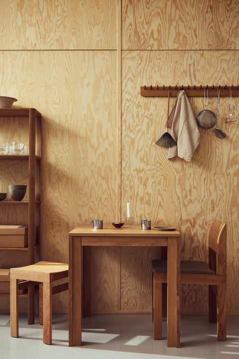 Form & Refine Leaf Shelf 0.5x5, tall oak shelving unit, tall oak shelf beside a square table with Sonder chairs against a plywood wall