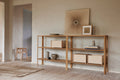 Form & Refine Leaf Shelf 2x3, solid oak shelving unit, long oak shelf in a hallway holding storage boxes and ceramics, artwork above