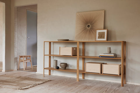Form & Refine Leaf Shelf 2x3, solid oak shelving unit, long oak shelf in a hallway holding storage boxes and ceramics, artwork above