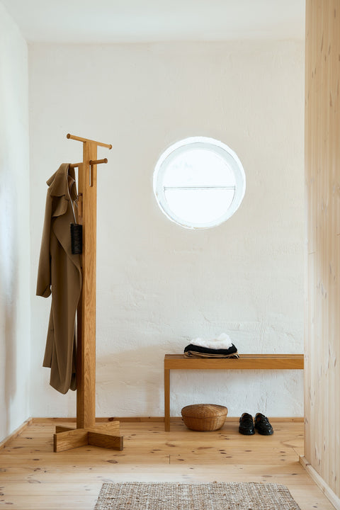 Form & Refine Lightweight Bench, solid oak slatted bench, oak bench under a coat stand in a whitewashed entrance with a round window