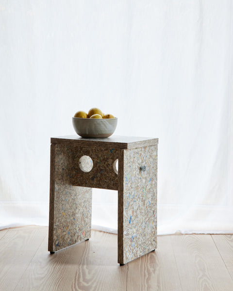 Form & Refine Remake Stool, recycled carton stool, the recycled-carton stool holding a bowl of lemons in front of a white curtain