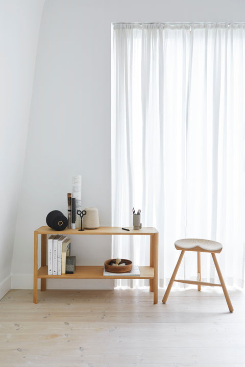 Form & Refine Shoemaker Chair™, No. 49, wooden Shoemaker stool, white oak Shoemaker stool beside a white oak Leaf Shelf in front of sheer curtains