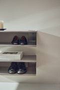 Form & Refine Taper Console & Shoe Rack 18x75, brushed stainless steel console shoe rack, the steel console holding shoes and a folded newspaper, close view