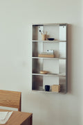 Form & Refine Taper Shelf 50x98, brushed stainless steel shelf unit, the Taper Shelf 50x98 on an office wall holding cups, a jar and papers