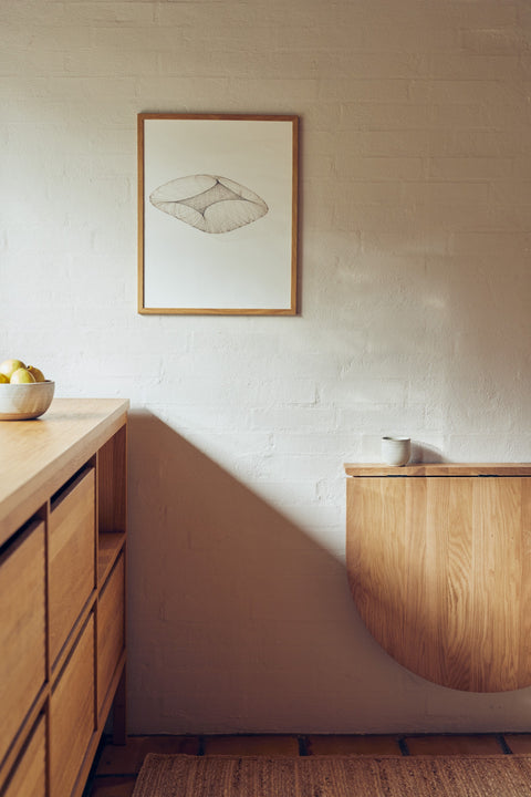 Form & Refine Trefoil Folding Wall Table, oak folding wall table, oak folding wall table folded down beside a kitchen counter under a framed drawing