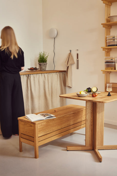 Form & Refine Trefoil Square Table, square oak dining table, square oak table beside the A Line Storage Bench in a kitchen with open shelving