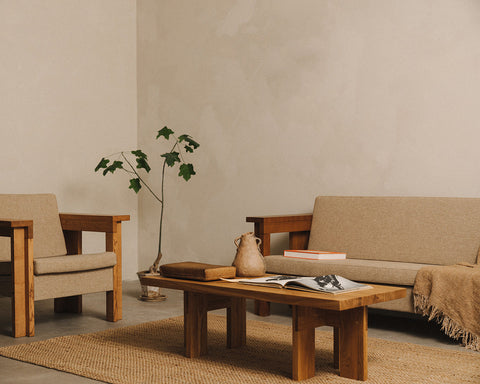 Frama Farmhouse Coffee Table in Natural Oak, long oak table with an open book and a pot in front of a linen sofa on a jute rug