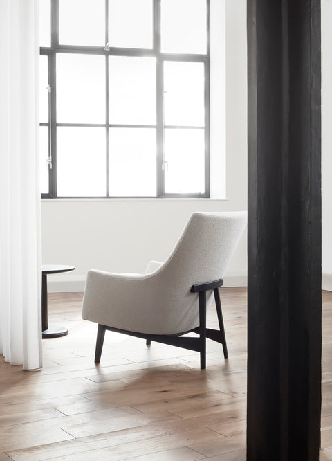 Fredericia Risom Lounge Chair in off white boucle with black stained oak frame in a modern loft